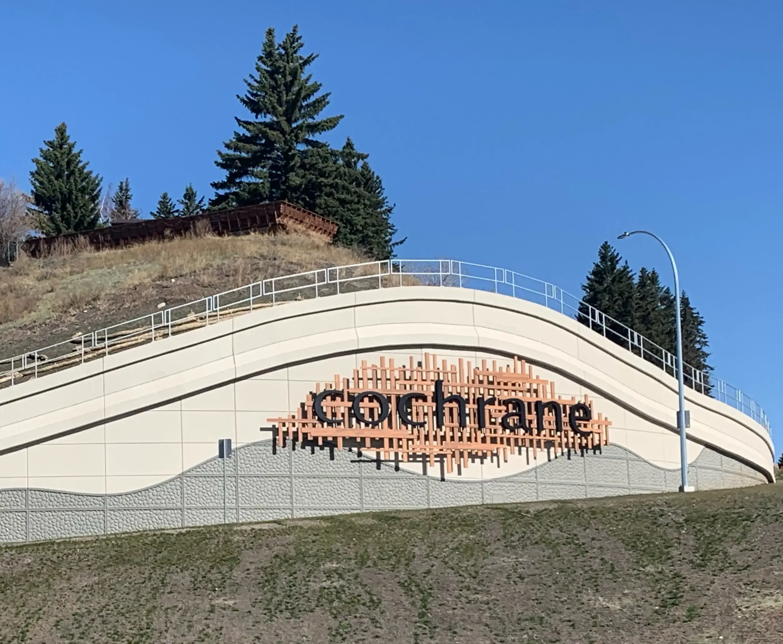 Cochrane community welcome sign with Rocky Mountain backdrop showcasing Can Do More Renovations service area